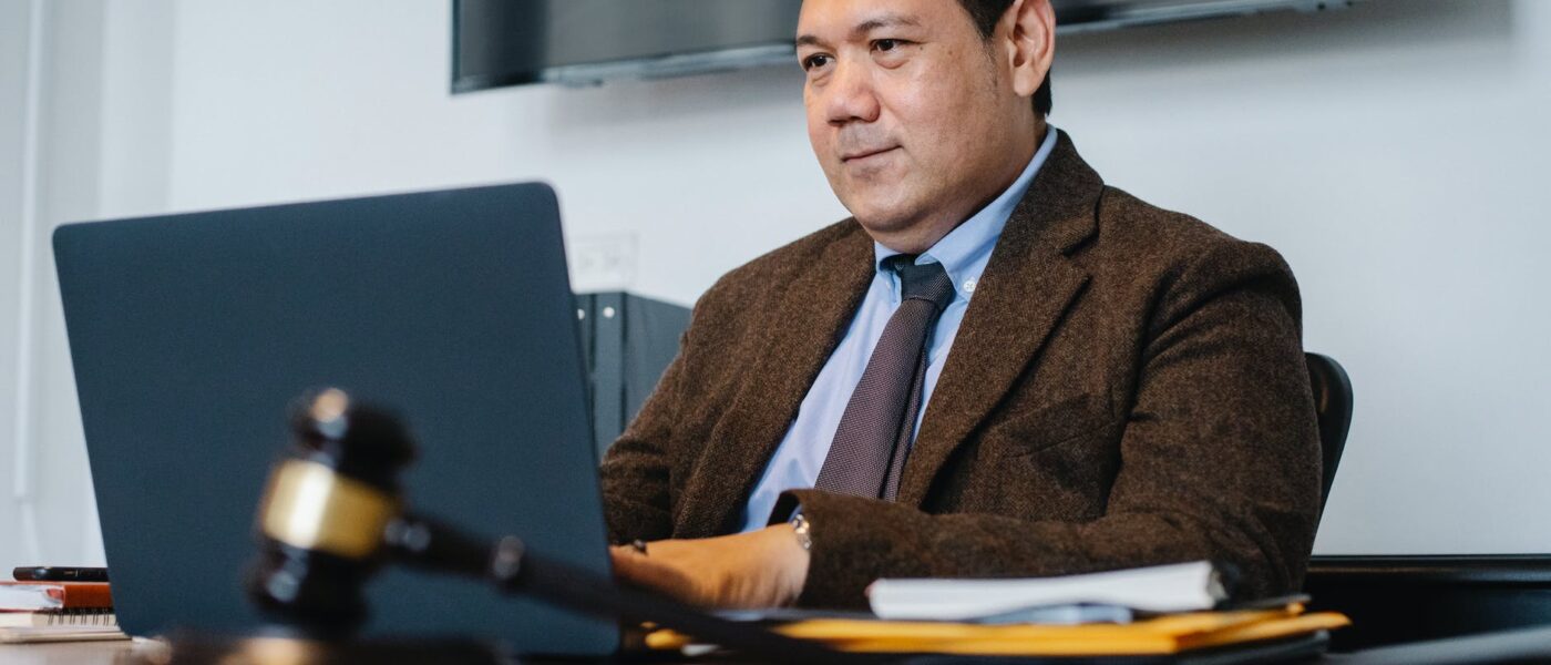 positive asian lawyer using laptop in modern office