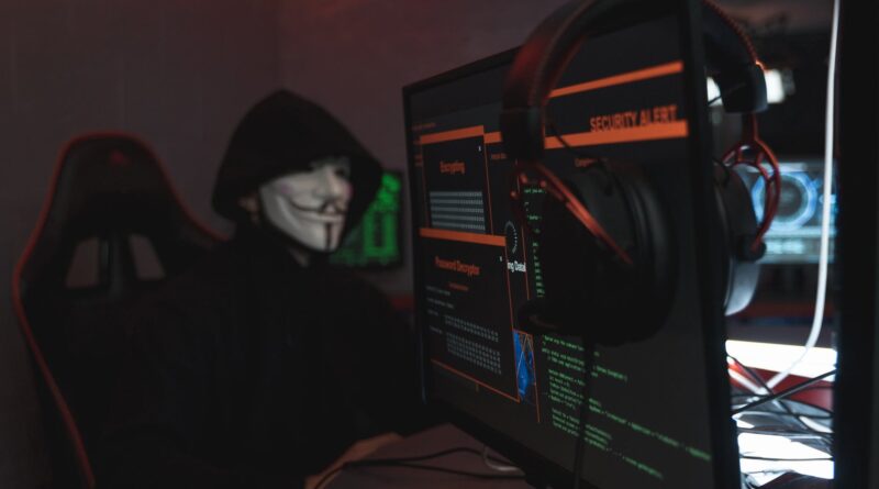person in black hoodie hacking a computer system